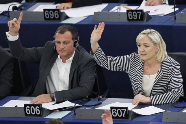 France's members of the European Parliament Marine Le Pen (R) and her companion Louis Aliot take part in a voting session at the European Parliament in Strasbourg, March 10, 2015.  REUTERS/Vincent Kessler